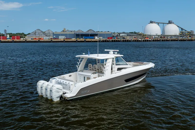 Slide: The Image of 2017 Boston Whaler 420 Outrage boat on water near industrial port. - 4