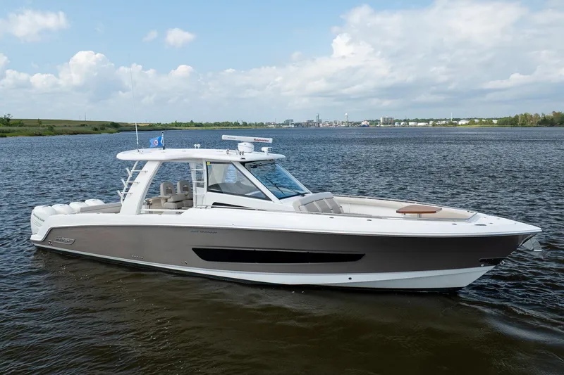 The Image of 2017 Boston Whaler 420 Outrage boat on calm water under a partly cloudy sky. - 0
