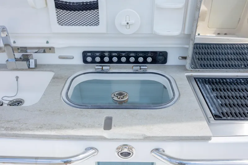 Slide: The Image of 2017 Boston Whaler 420 Outrage boat kitchen with sink, grill, and control panel. - 43