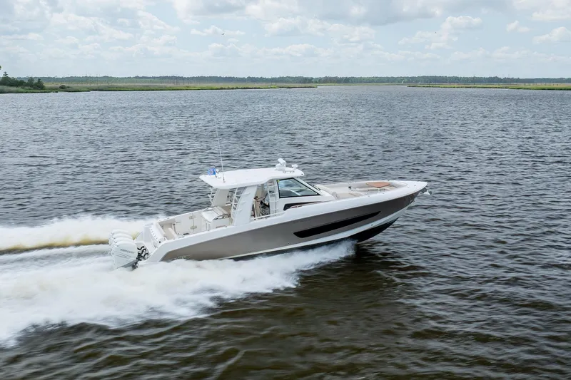 Slide: The Image of 2017 Boston Whaler 420 Outrage cruising on open water under a cloudy sky. - 17