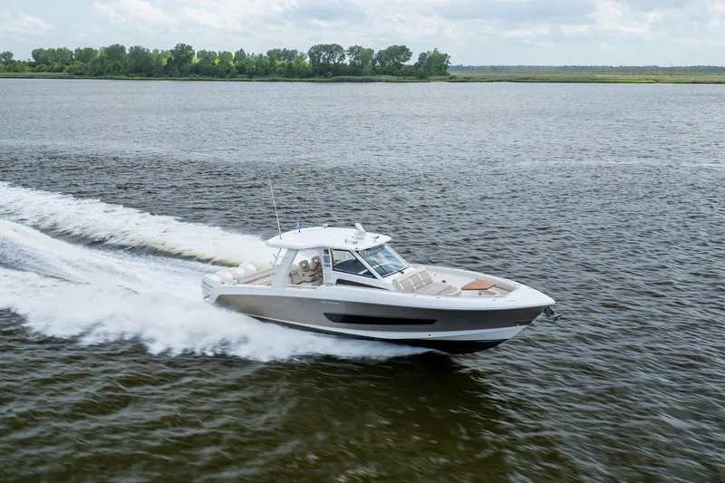 Slide: The Image of 2017 Boston Whaler 420 Outrage cruising on a calm lake under cloudy skies. - 16