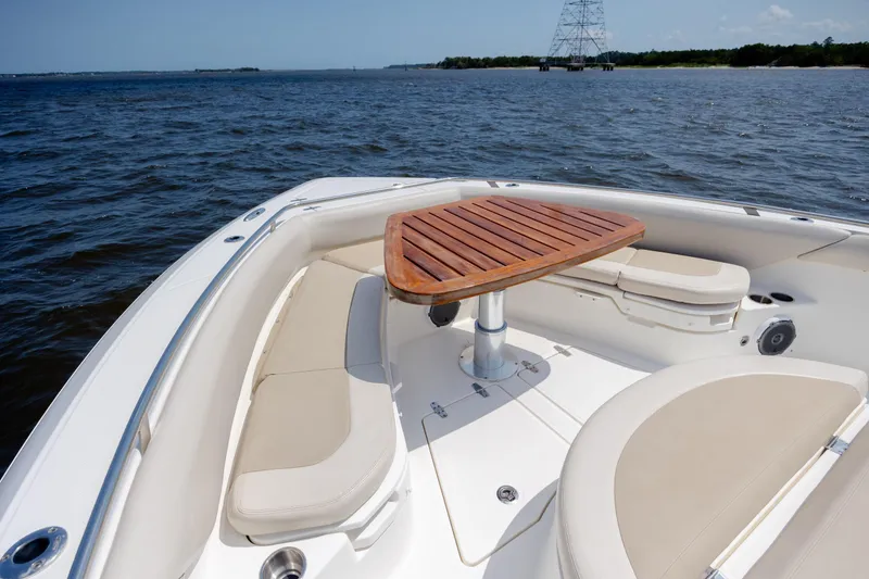 Slide: The Image of 2017 Boston Whaler 420 Outrage boat with cushioned seating and wooden table on open water. - 63