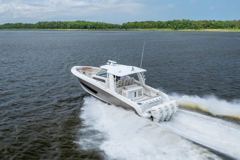 Slide: The Image of 2017 Boston Whaler 420 Outrage cruising on open water, showcasing powerful engines and sleek design. - 14
