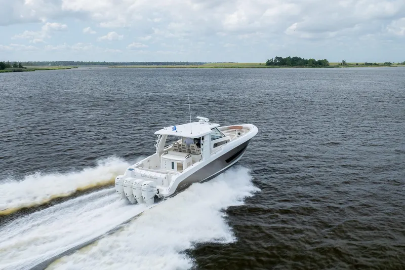 Slide: The Image of 2017 Boston Whaler 420 Outrage cruising on open water under cloudy skies. - 12