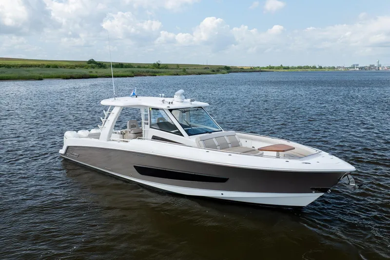 Slide: The Image of 2017 Boston Whaler 420 Outrage boat on calm water under a cloudy sky. - 2