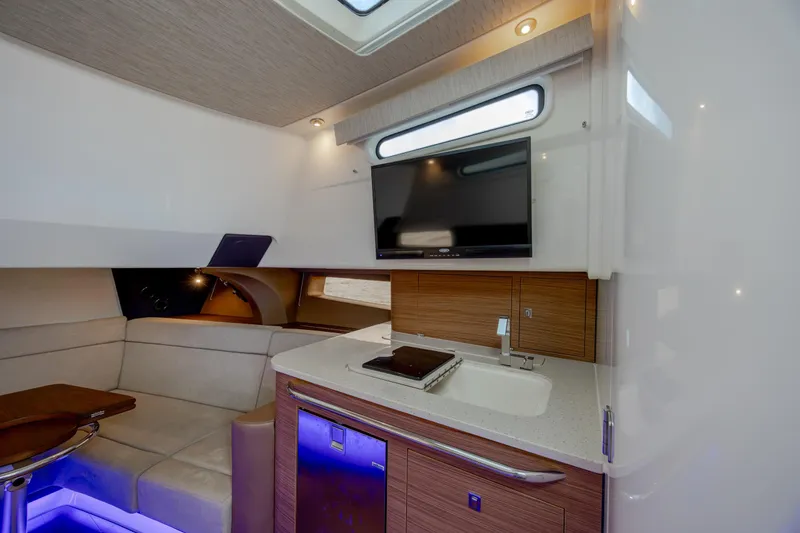 Slide: The Image of Luxurious interior of 2017 Boston Whaler 420 Outrage with seating, kitchenette, and TV. - 34