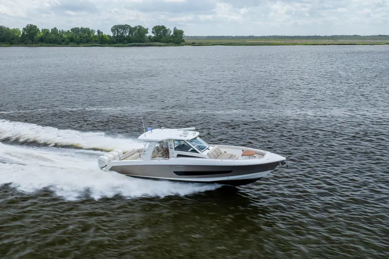 Slide: The Image of 2017 Boston Whaler 420 Outrage cruising on a calm river under a cloudy sky. - 10