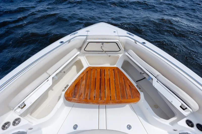 Slide: The Image of 2017 Boston Whaler 420 Outrage boat bow with wooden seating, on open water. - 64