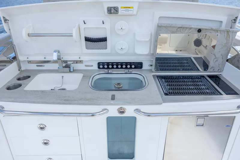 Slide: The Image of Outdoor kitchen on 2017 Boston Whaler 420 Outrage, featuring sink, grill, and storage. - 41