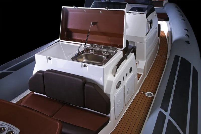 Slide: The Image of 2027 Brig Eagle 10 boat interior with kitchenette and seating on teak deck. - 5