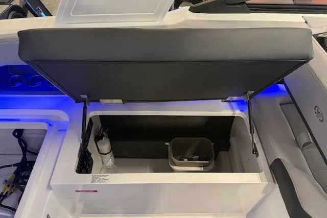 Slide: The Image of 2026 Cobalt R6 boat storage compartment with open lid and interior lighting. - 9