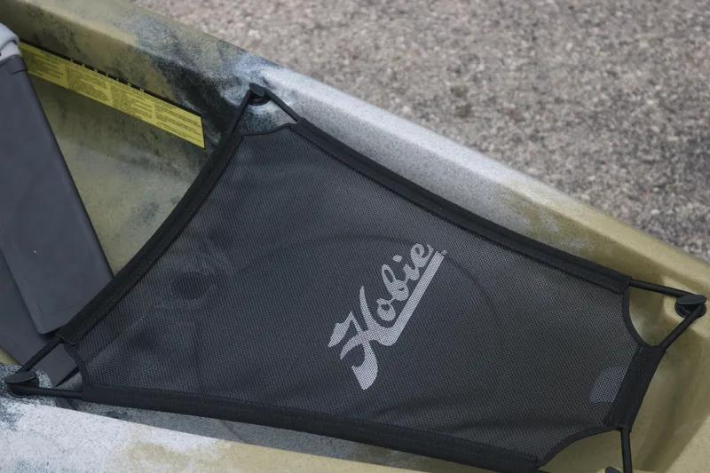 Slide: The Image of 2023 Hobie Mirage Compass kayak with mesh storage cover, showcasing brand logo. - 4