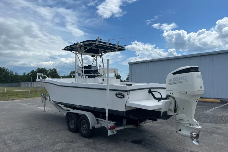 Slide: The Image of 2007 Duskey 256 boat with Suzuki engine on trailer, parked outdoors under cloudy sky. - 3