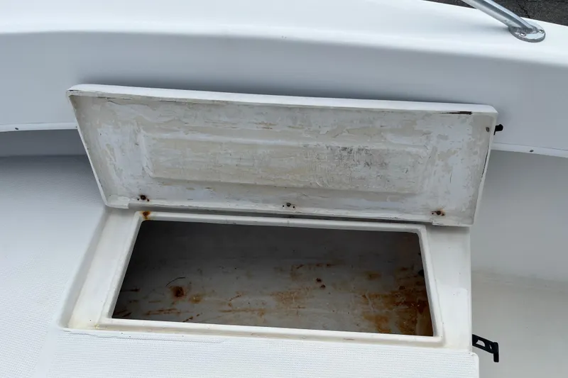 Slide: The Image of Open storage compartment on a 2007 Duskey 256 boat, showing interior wear. - 10