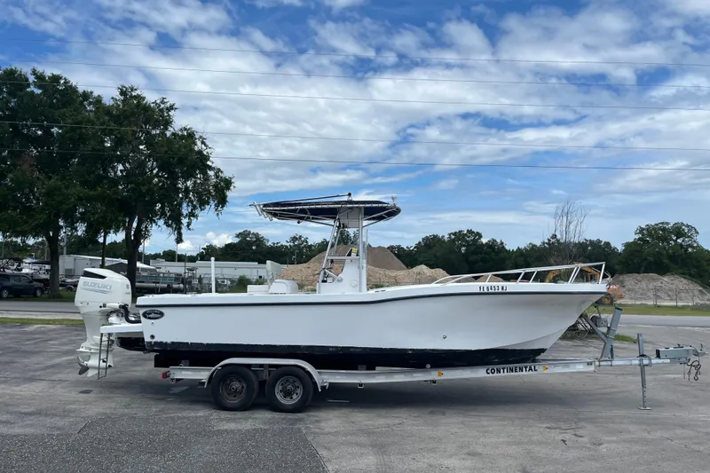 Slide: The Image of ```json { "alt_text": "2007 Duskey 256 boat on trailer with Suzuki engine, parked outdoors." } ``` - 4