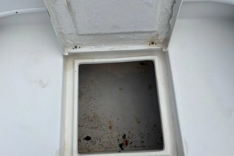 Slide: The Image of Open storage compartment on a 2007 Duskey 256 boat, showing interior wear. - 9