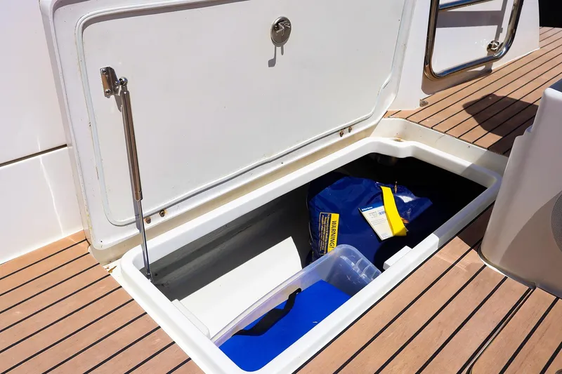 Slide: The Image of Open storage compartment on 2022 MJM 3z boat with safety equipment inside. - 40