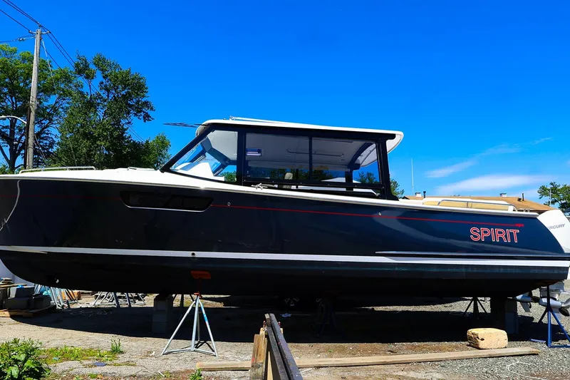 Slide: The Image of 2022 MJM 3z boat named "Spirit" on stands, under clear blue sky. - 4