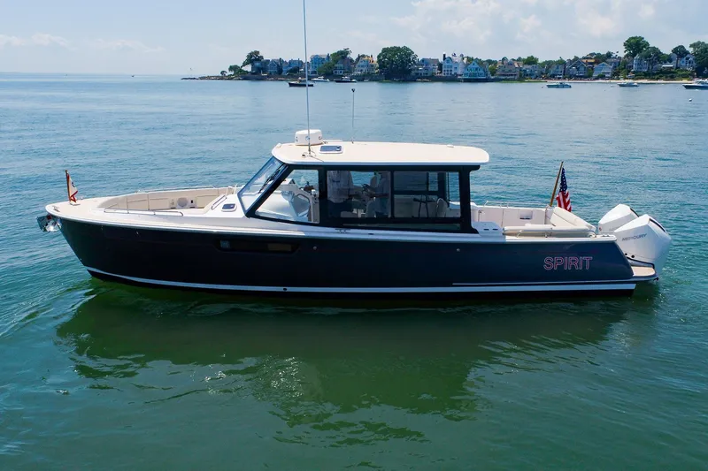 Slide: The Image of 2022 MJM 3z boat on calm water, near a coastal town. - 3