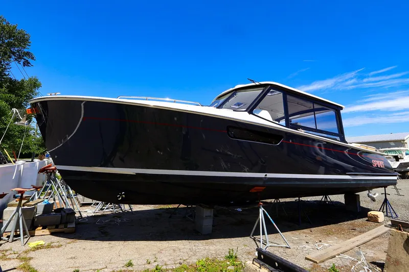 Slide: The Image of 2022 MJM 3z boat on stands, sleek design, under clear blue sky. - 5