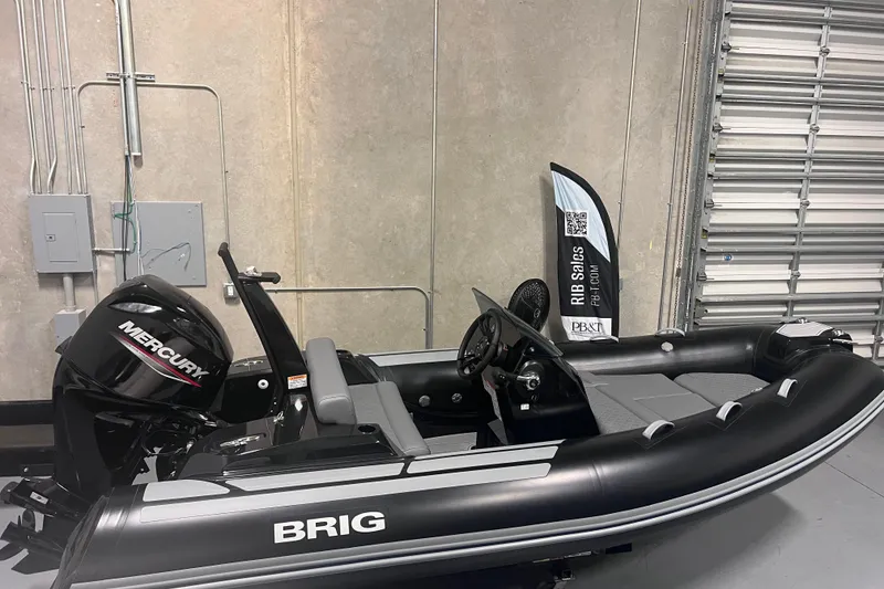 Slide: The Image of 2026 Brig Eagle 4 inflatable boat with Mercury engine in a garage setting. - 1