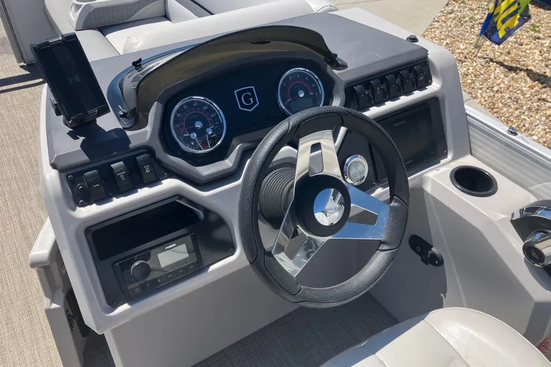 Slide: The Image of 2023 Godfrey Sweetwater 2286 BF boat dashboard with steering wheel and control panel. - 8