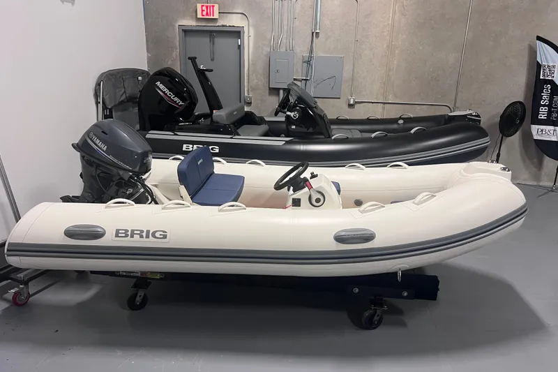 Slide: The Image of 2026 Brig Falcon 360 inflatable boats in showroom, featuring Yamaha and Mercury engines. - 1