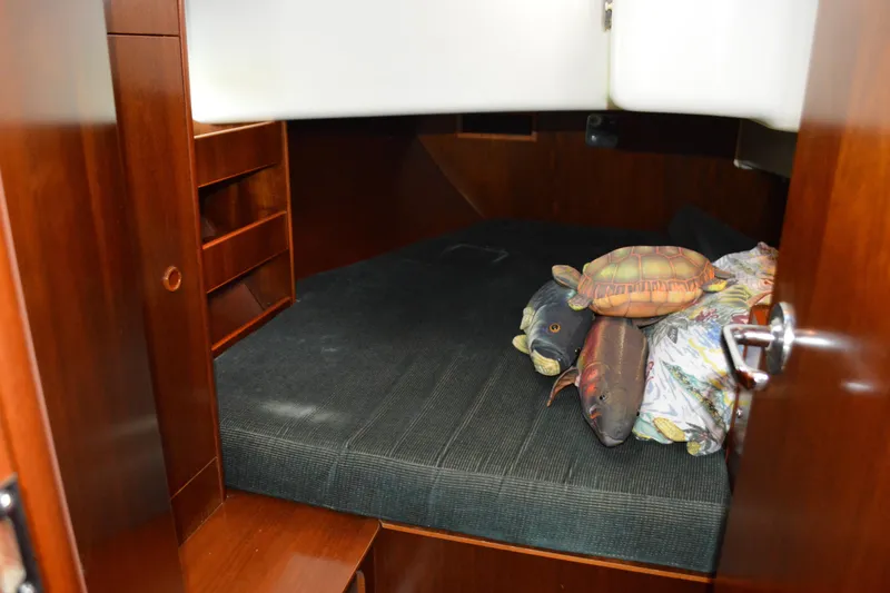 Slide: The Image of Cozy cabin interior of 1999 Beneteau 411 sailboat with plush toys on bed. - 35