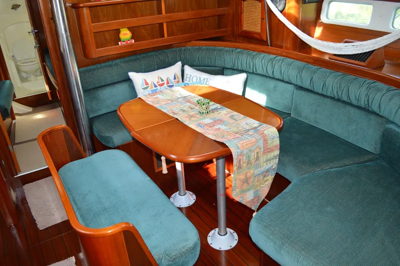 Slide: The Image of Interior of 1999 Beneteau 411 yacht with cozy seating and decorative table runner. - 24