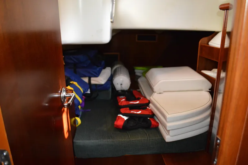 Slide: The Image of Interior storage area of a 1999 Beneteau 411 sailboat with cushions and gear. - 36