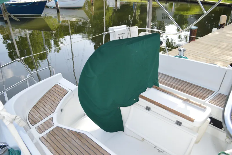 Slide: The Image of Cockpit of a 1999 Beneteau 411 sailboat with green cover and wooden accents. - 9