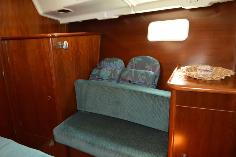 Slide: The Image of Interior of 1999 Beneteau 411 sailboat with wooden cabinetry and cushioned seating. - 42
