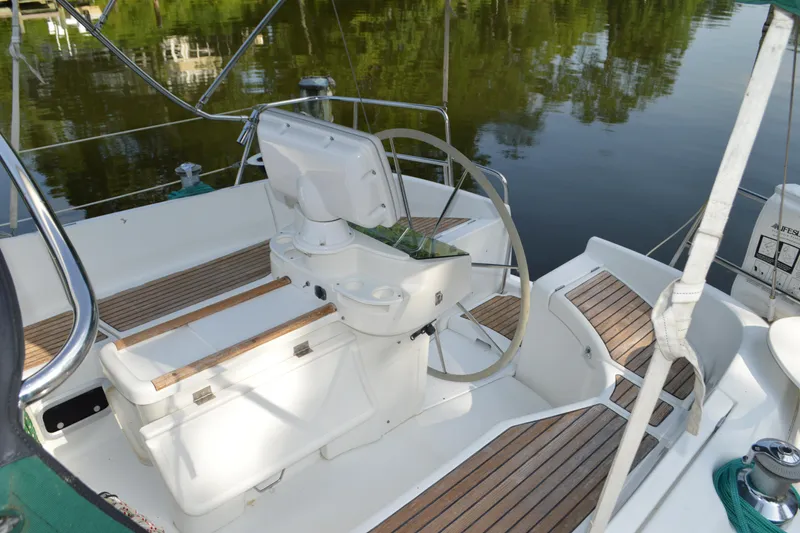 Slide: The Image of Cockpit of a 1999 Beneteau 411 sailboat with wooden seating and steering wheel. - 13