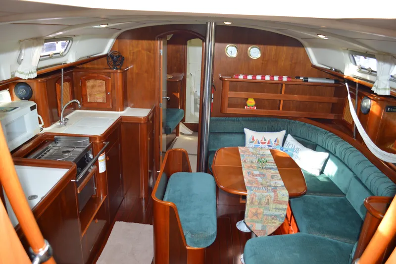 Slide: The Image of Interior of a 1999 Beneteau 411 sailboat with cozy seating and kitchen area. - 21
