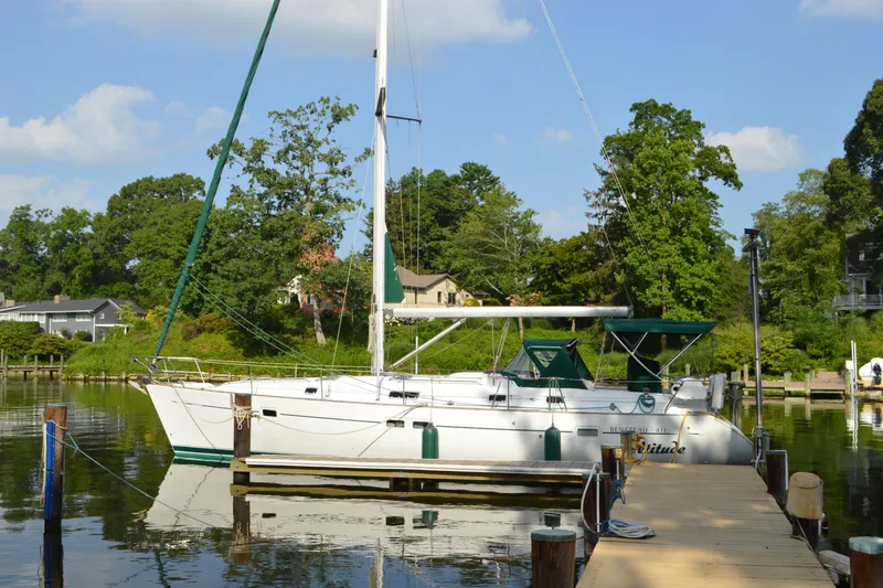 The Image of Sailboat Beneteau 411, 1999 model, docked in a serene marina setting. - 0