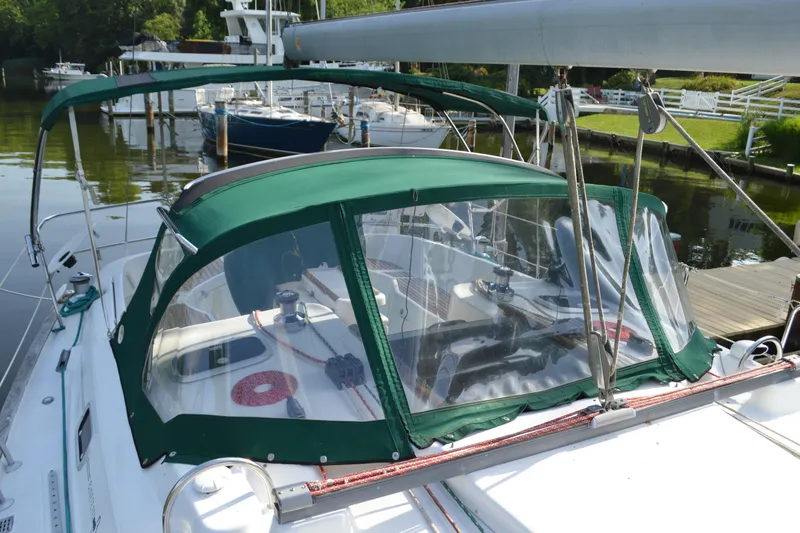 Slide: The Image of 1999 Beneteau 411 sailboat with green canopy docked in a marina. - 8