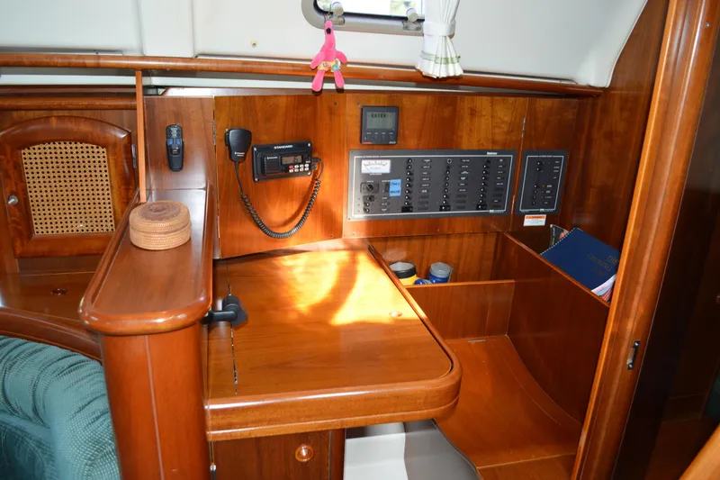 Slide: The Image of Interior of a 1999 Beneteau 411 sailboat with navigation equipment and wooden cabinetry. - 32