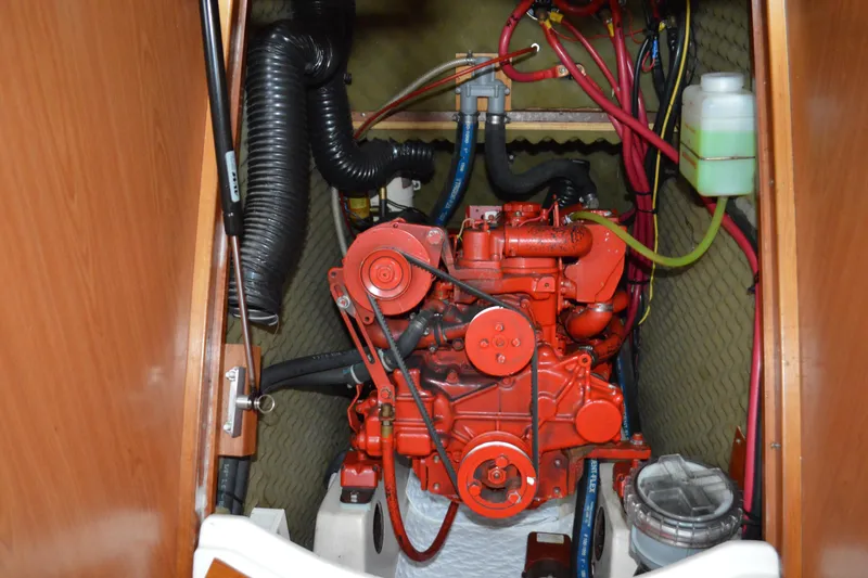 Slide: The Image of Engine compartment of a 1999 Beneteau 411 sailboat, featuring a red marine engine. - 48