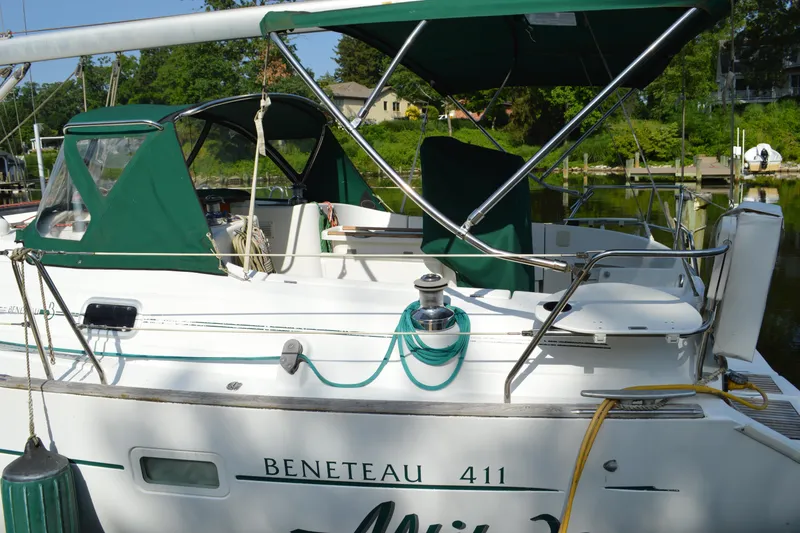 Slide: The Image of 1999 Beneteau 411 sailboat docked, featuring green canopy and clean white deck. - 4