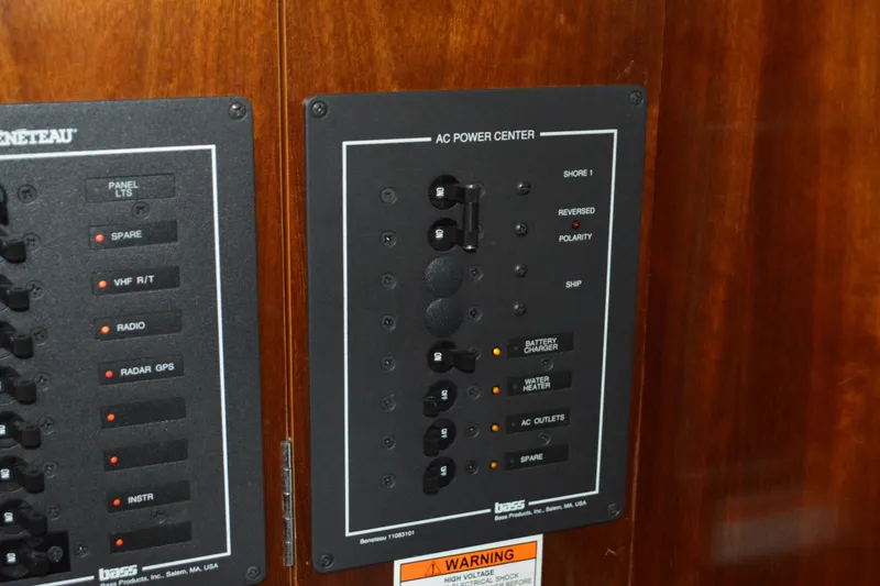 Slide: The Image of Electrical panel on a 1999 Beneteau 411 yacht, featuring AC power controls and switches. - 34