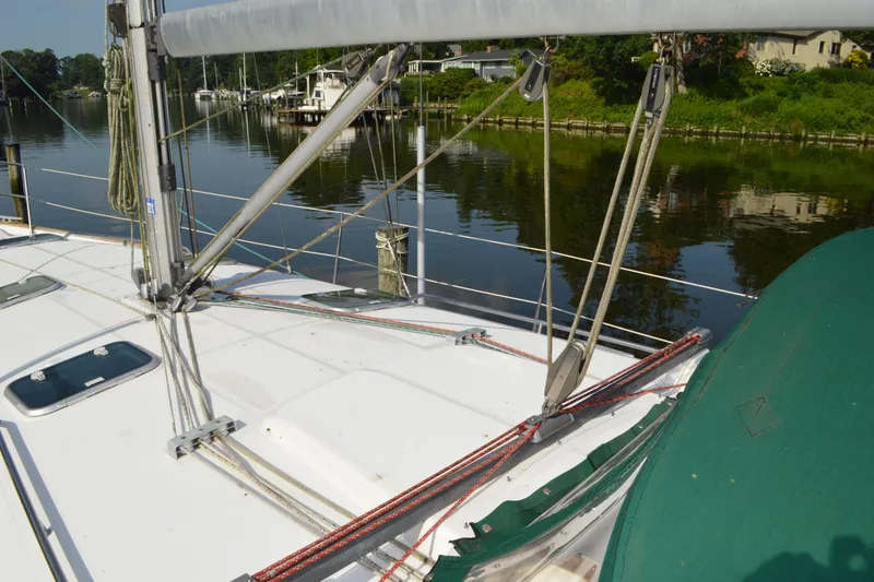 Slide: The Image of Deck view of a 1999 Beneteau 411 sailboat, featuring rigging and calm waters. - 18