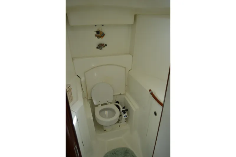 Slide: The Image of Bathroom interior of a 1999 Beneteau 411 yacht, featuring a compact marine toilet. - 43