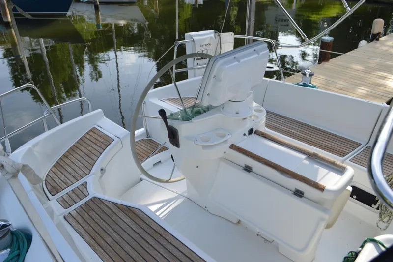 Slide: The Image of Cockpit of a 1999 Beneteau 411 sailboat with wooden seating and steering wheel. - 14