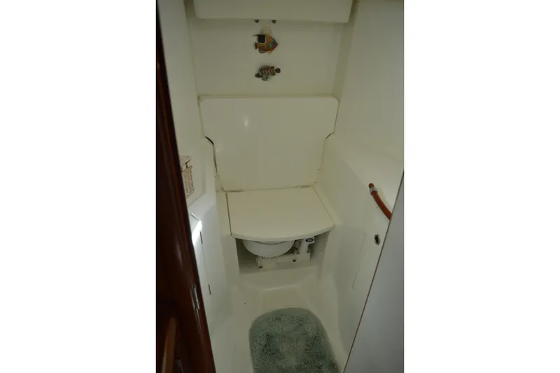 Slide: The Image of Bathroom interior of a 1999 Beneteau 411 yacht, featuring compact design and white fixtures. - 44