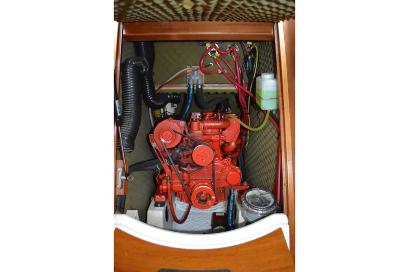 Slide: The Image of Engine compartment of a 1999 Beneteau 411 sailboat, featuring a red marine engine. - 47