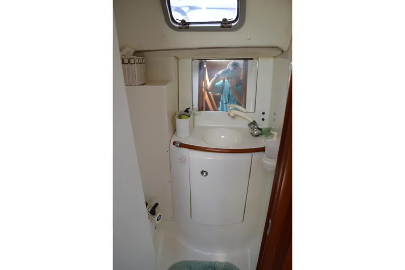 Slide: The Image of Bathroom interior of a 1999 Beneteau 411 yacht, featuring a compact sink and mirror. - 38