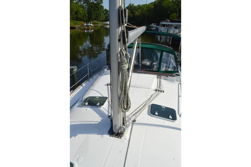 Slide: The Image of Sailboat deck view of 1999 Beneteau 411, featuring mast and rigging in a serene marina. - 19