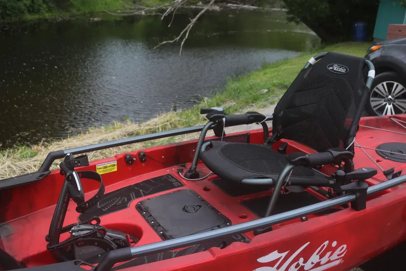 Slide: The Image of 2023 Hobie Mirage Pro Angler 14 kayak by a serene riverside. - 3
