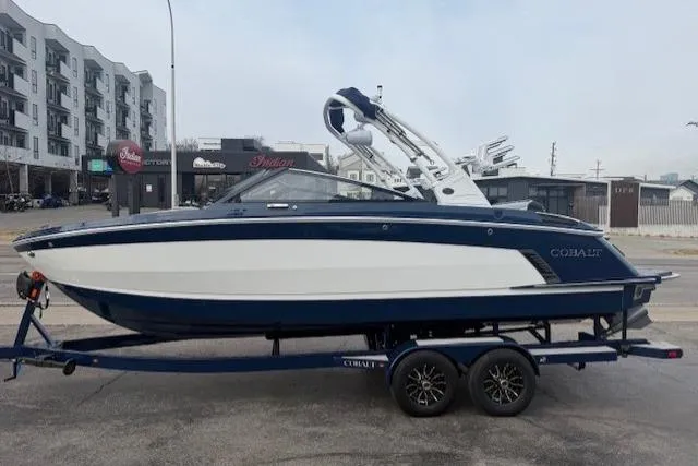 Slide: The Image of 2026 Cobalt R6 Surf boat on trailer, parked in urban setting. - 3
