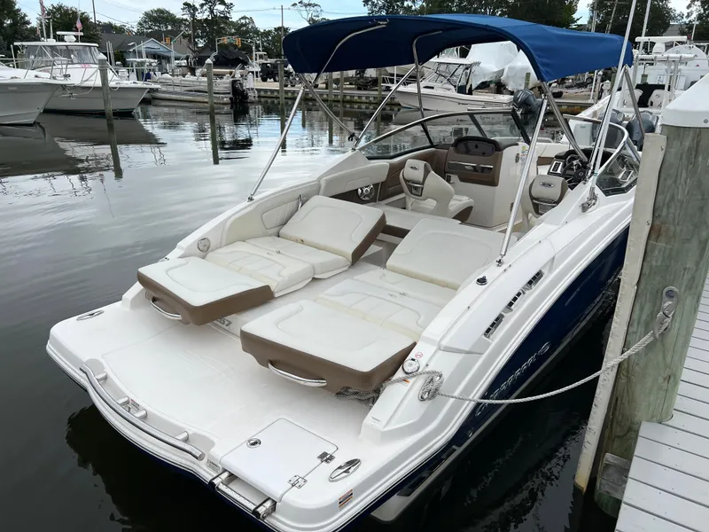 Slide: The Image of A 2016 Chaparral 257 SSX boat docked, featuring a blue sunshade. - 22